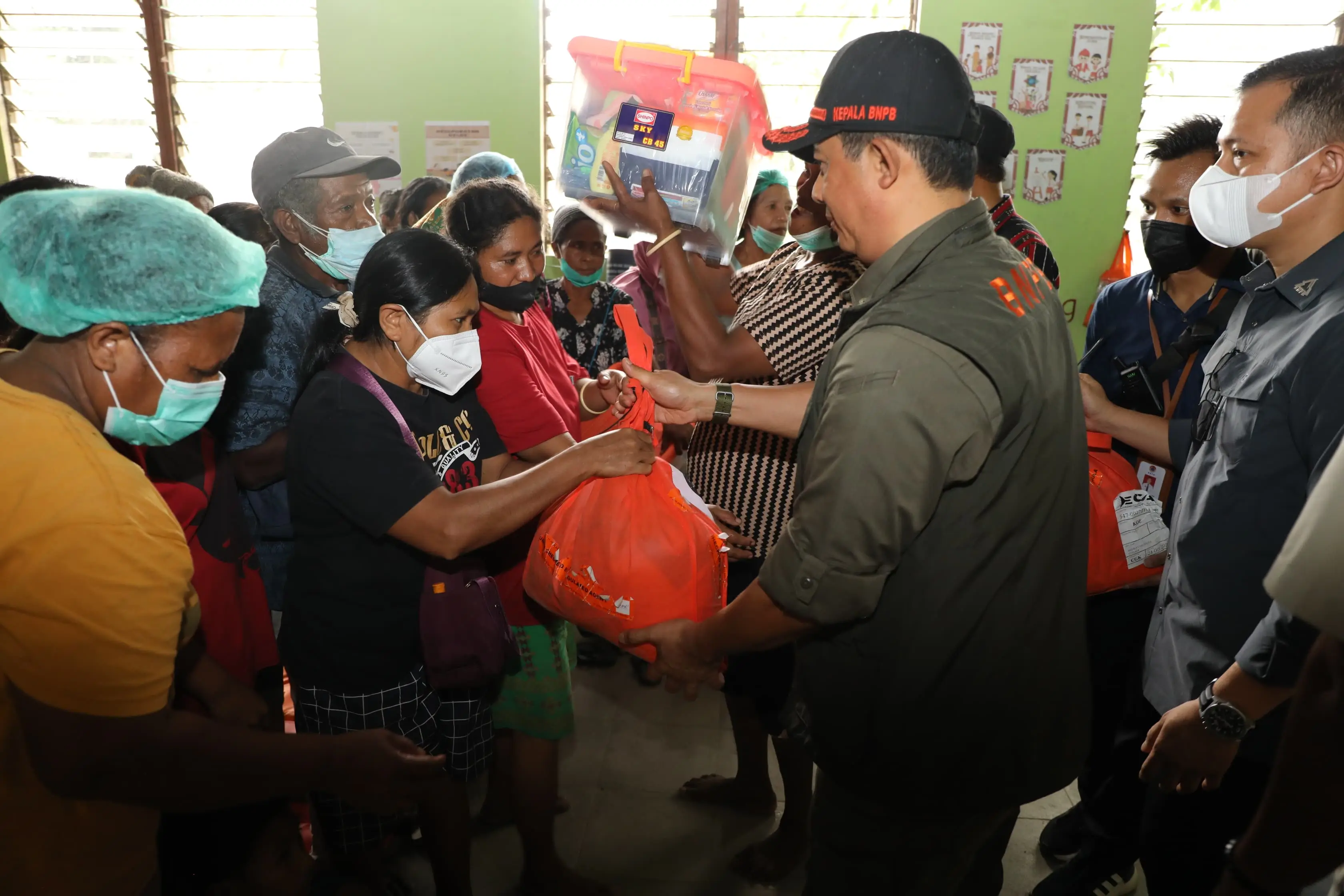 Kepala Badan Nasional Penanggulangan Bencana (BNPB) Letjen TNI Dr. Suharyanto, S.Sos., M.M (kemeja dan rompi hijau) saat memberikan bantuan kepada pengungsi yang berada di Desa Hikong, Kabupaten Sikka, Nusa Tenggara Timur pada Jumat (8/11).